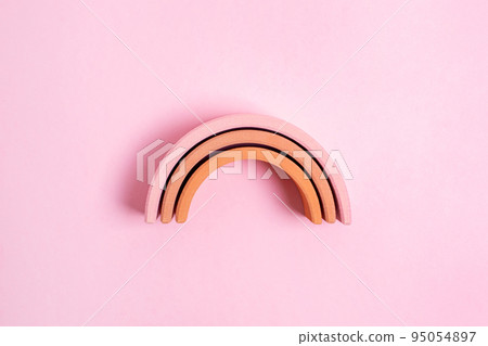 Education kid arch toy , pastel pyramid game on pink background. Colorful wooden figure on yellow background, kid play concept Education kid arch toy , pastel pyramid game on pink background. Colorful wooden figure on yellow background, kid play concept 95054897