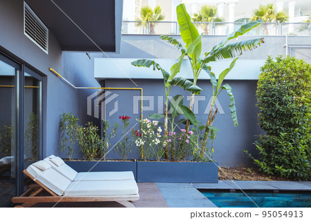 Beautiful luxury umbrella and chair around outdoor swimming pool in hotel and resort with coconut palm tree on blue sky  95054913