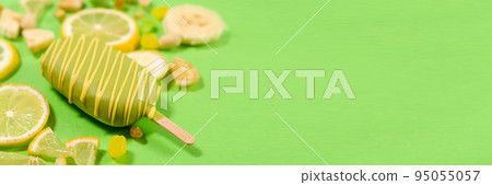 Yellow ice cream on a stick, bananas and lemons on a green background, place for text Yellow ice cream on a stick, bananas and lemons on a green background, place for text 95055057