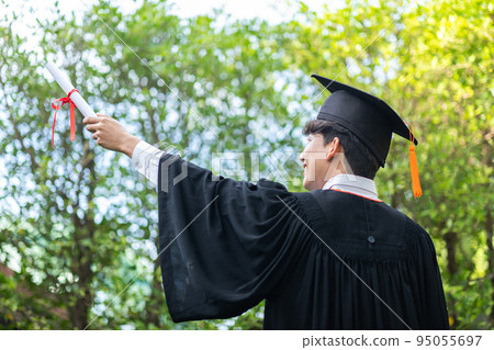 Back of view Asian Graduate man put hands up and celebrating with certificate in hand so proud and happiness in Commencement day. Congratulation of student in graduation day. Education Success Concept 95055697