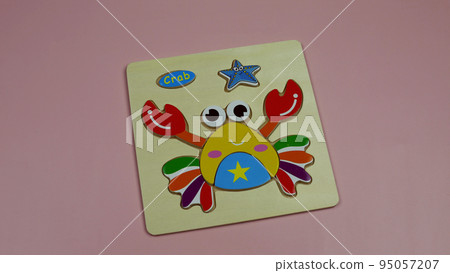 Wooden puzzle for children depicting a crab. Flat painting made of wooden parts 95057207