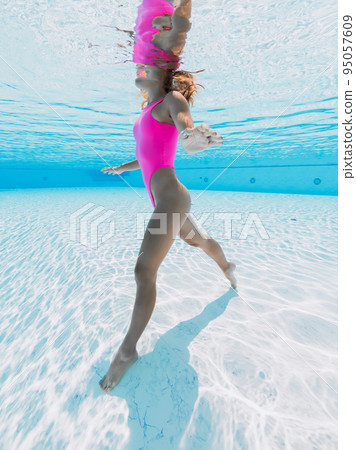 Young woman in pink bikini in pool Young woman in pink bikini in pool 95057609