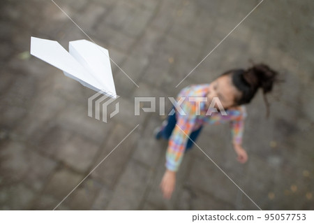 girl flying a paper plane 95057753
