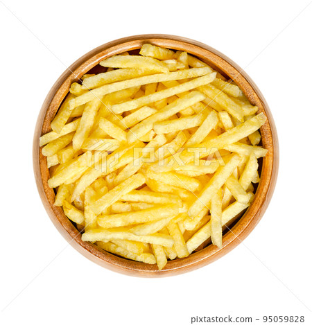 Salted potato sticks in a wooden bowl. Also called shoestring potatoes, a popular snack and variant of crispy potato chips. Extremely thin versions of French fries, deep fried in sunflower oil. 95059828