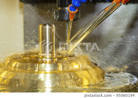 The CNC milling machine cutting the brass material part with oil coolant method. 95060194