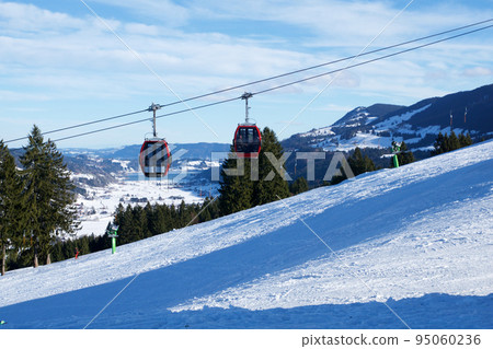 OBERSTAUFEN, GERMANY - 31 DEC, 2017: Ski lift with gondola cable car and ski slope in the foreground 95060236