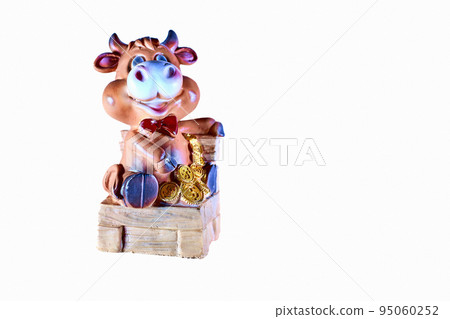 Toy cow sitting on a chair with gold coins money 95060252