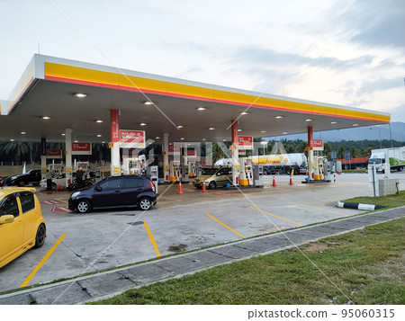 JOHOR, MALAYSIA - APRIL 6, 2022: Shell gas station in operation. Customers stop to refuel and buy goods. Several classes of petrol and diesel are sold here. JOHOR, MALAYSIA - APRIL 6, 2022: Shell gas station in operation. Customers stop to refuel and buy goods. Several classes of petrol and diesel are sold here. 95060315