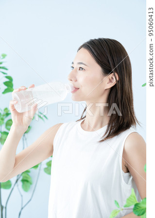A young woman drinking water in a plastic bottle 95060413