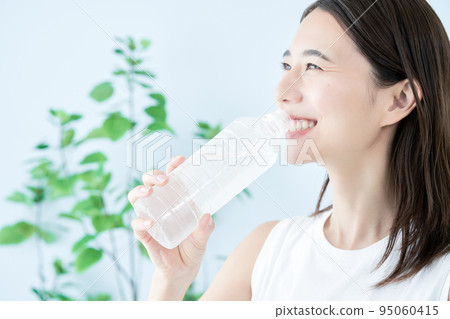 在塑料瓶的一個少婦飲用水 95060415