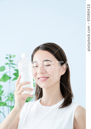 在塑料瓶的一個少婦飲用水 95060418