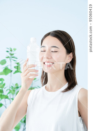 在塑料瓶的一個少婦飲用水 在塑料瓶的一個少婦飲用水 95060419