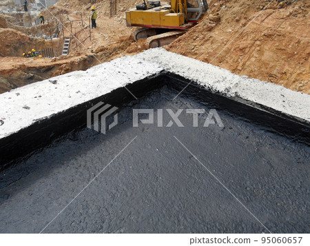 MELAKA, MALAYSIA -JULY 1, 2022: Waterproofing membrane applied by construction workers on top of the concrete slab. Waterproofing layer to prevent water from penetrating below the concrete slab. MELAKA, MALAYSIA -JULY 1, 2022: Waterproofing membrane applied by construction workers on top of the concrete slab. Waterproofing layer to prevent water from penetrating below the concrete slab. 95060657