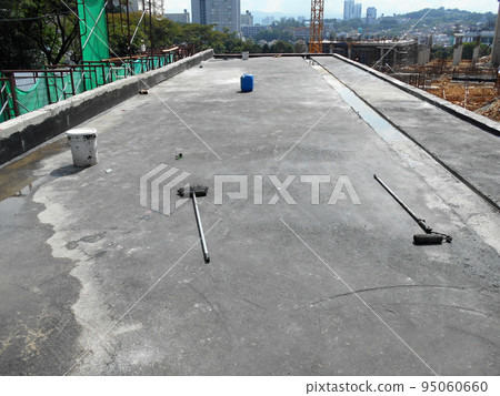 MELAKA, MALAYSIA -JULY 1, 2022: Waterproofing membrane applied by construction workers on top of the concrete slab. Waterproofing layer to prevent water from penetrating below the concrete slab. MELAKA, MALAYSIA -JULY 1, 2022: Waterproofing membrane applied by construction workers on top of the concrete slab. Waterproofing layer to prevent water from penetrating below the concrete slab. 95060660
