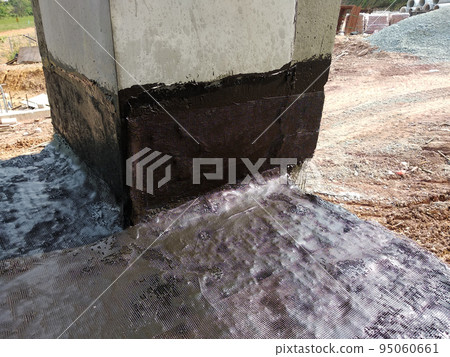 MELAKA, MALAYSIA -JULY 1, 2022: Waterproofing membrane applied by construction workers on top of the concrete slab. Waterproofing layer to prevent water from penetrating below the concrete slab. MELAKA, MALAYSIA -JULY 1, 2022: Waterproofing membrane applied by construction workers on top of the concrete slab. Waterproofing layer to prevent water from penetrating below the concrete slab. 95060661