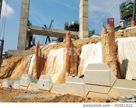 MELAKA, MALAYSIA - JULY 6, 2022: Slopes that have been cut, are temporarily covered using plastic or fabric for a while to prevent erosion caused by rainwater. This is as an immediate action. 95061822