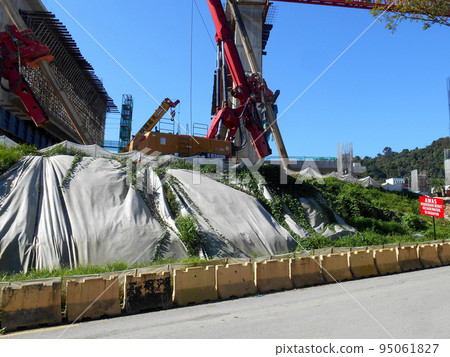 MELAKA, MALAYSIA - JULY 6, 2022: Slopes that have been cut, are temporarily covered using plastic or fabric for a while to prevent erosion caused by rainwater. This is as an immediate action. 95061827