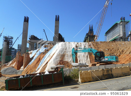 MELAKA, MALAYSIA - JULY 6, 2022: Slopes that have been cut, are temporarily covered using plastic or fabric for a while to prevent erosion caused by rainwater. This is as an immediate action. 95061829