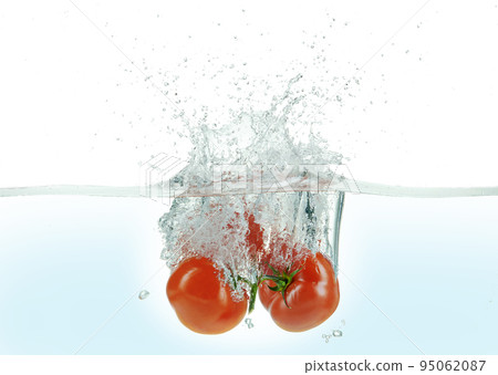 Three tomatoes splashing in water. Three tomatoes splashing in water. 95062087