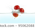 Three tomatoes splashing in water. 95062088