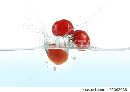 Three tomatoes splashing in water. 95062088