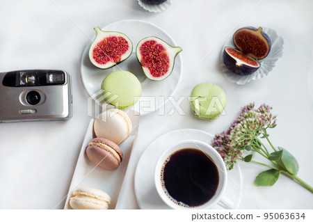 aesthetic film camera flatlay, cups of coffee, figs and macarons on a white background, top view aesthetic film camera flatlay, cups of coffee, figs and macarons on a white background, top view 95063634