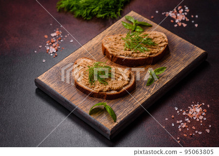Homemade meat snack liver pate with toast on a dark concrete background Homemade meat snack liver pate with toast on a dark concrete background 95063805