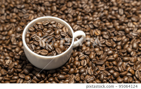 Texture of coffee beans. Food background of coffee beans. A cup of coffee full of coffee beans. 95064124