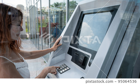 Caucasian woman buying tickets from the machine. 95064536