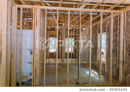 Under construction beam framing structure of a timber frame home on the construction site for a new residential project Under construction beam framing structure of a timber frame home on the construction site for a new residential project 95065244