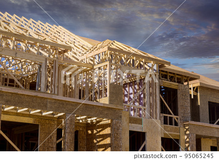 Under construction new residential building frame structure beams framing, home wood frame, on construction site for the new residential unit Under construction new residential building frame structure beams framing, home wood frame, on construction site for the new residential unit 95065245