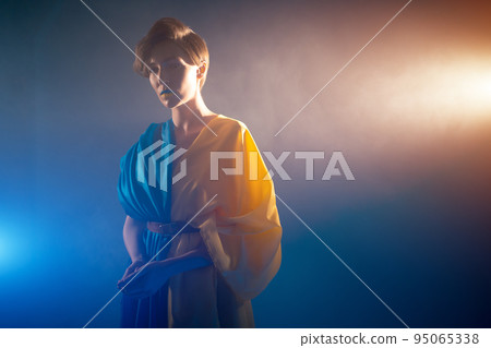 young ukrainian woman in yellow and blue clothes and dress praying for ukraine 95065338