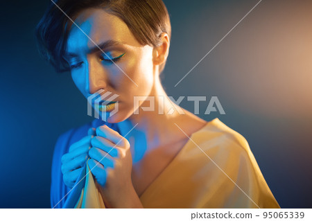 young ukrainian woman in yellow and blue clothes and dress praying for ukraine 95065339
