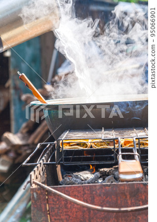 on the grill stands a cauldron in which to prepare meat and vegetables 95066901