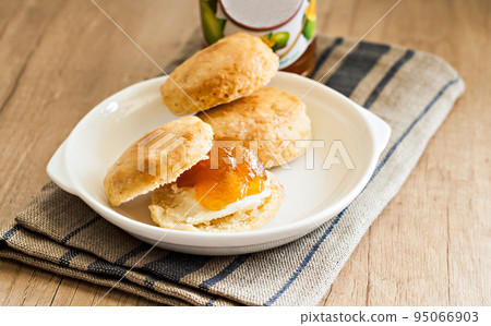 scones with butter and jam on a napkin and Bank of jam 95066903