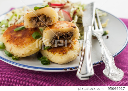 fried potato pies with mushrooms and salad on a plate 95066917