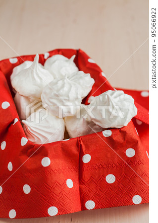 Small meringues meringue on a red background 95066922