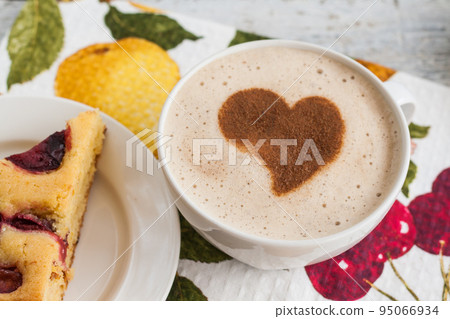 Pie with plums and a cup of coffee and heart Pie with plums and a cup of coffee and heart 95066934