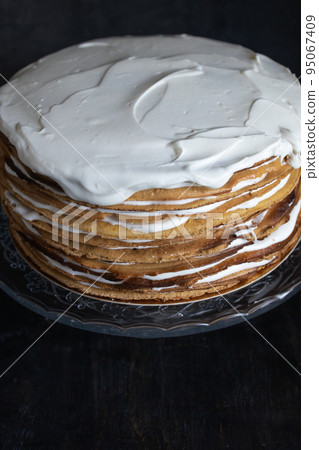 a whole round honey cake on a stand against a dark background a whole round honey cake on a stand against a dark background 95067409