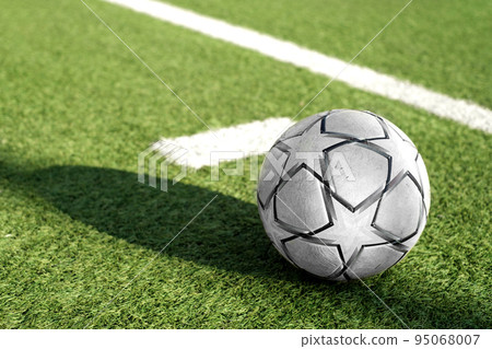 White and black soccer ball with stars on a sports field with artificial green grass White and black soccer ball with stars on a sports field with artificial green grass 95068007