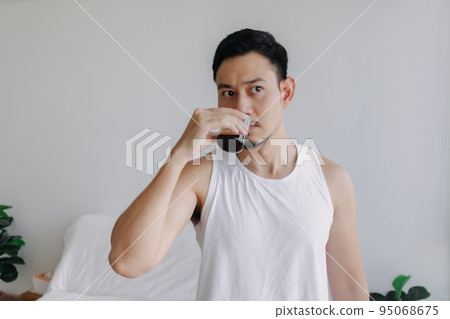 Asian man dink a shot of espresso coffee in his house for fresh morning. Asian man dink a shot of espresso coffee in his house for fresh morning. 95068675