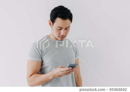 Asian man concentrated on smartphone isolated on white background. Asian man concentrated on smartphone isolated on white background. 95068692