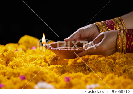 Traditional diya lamps lit during diwali celebration Traditional diya lamps lit during diwali celebration 95068710