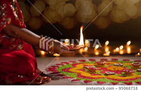 Traditional diya lamps lit during diwali celebration Traditional diya lamps lit during diwali celebration 95068718