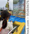 A girl playing hard at an amusement park 95069476