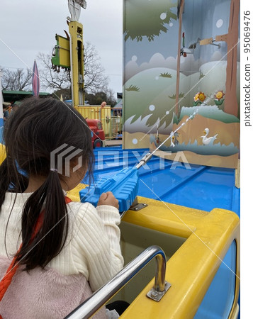 A girl playing hard at an amusement park A girl playing hard at an amusement park 95069476