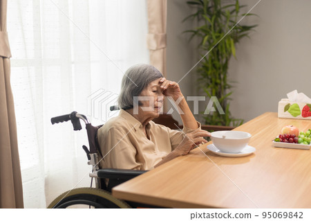 Lonely senior asian woman bored with food. Lonely senior asian woman bored with food. 95069842