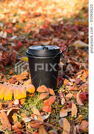 Mock up paper coffee cup against autumn coloured leaves. Disposable coffee cup, fall mood composition. Mock up paper coffee cup against autumn coloured leaves. Disposable coffee cup, fall mood composition. 95069920