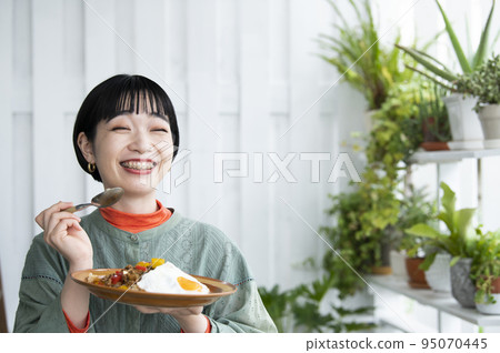 Young woman eating gapao rice 95070445