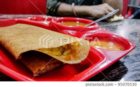 Masala dosa is a South Indian meal served with sambhar and coconut chutney. Selective focus Masala dosa is a South Indian meal served with sambhar and coconut chutney. Selective focus 95070530